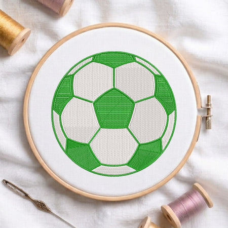 Embroidery hoop with a green and white soccer ball design on a light background.