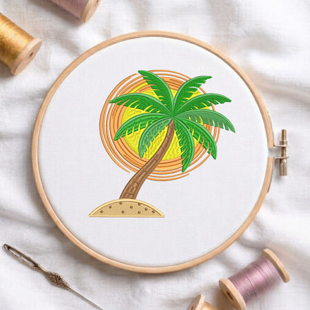 A wooden embroidery hoop holds white fabric with a palm tree design in front of an orange and yellow sun motif. The hoop is styled on a white fabric background with spools of thread and a needle nearby.
