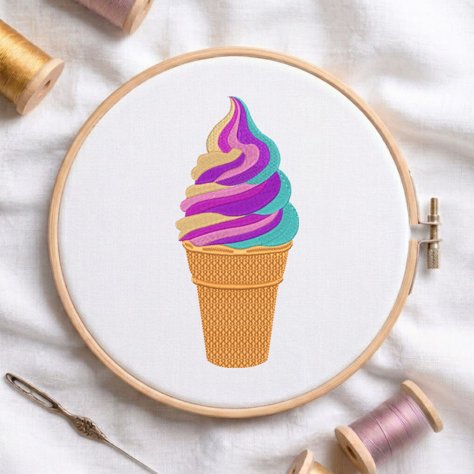 A circular embroidery hoop on white fabric, featuring a colorful ice cream swirl design in purple, teal, and gold. Spools of thread and a needle are arranged around the hoop on a white fabric background.