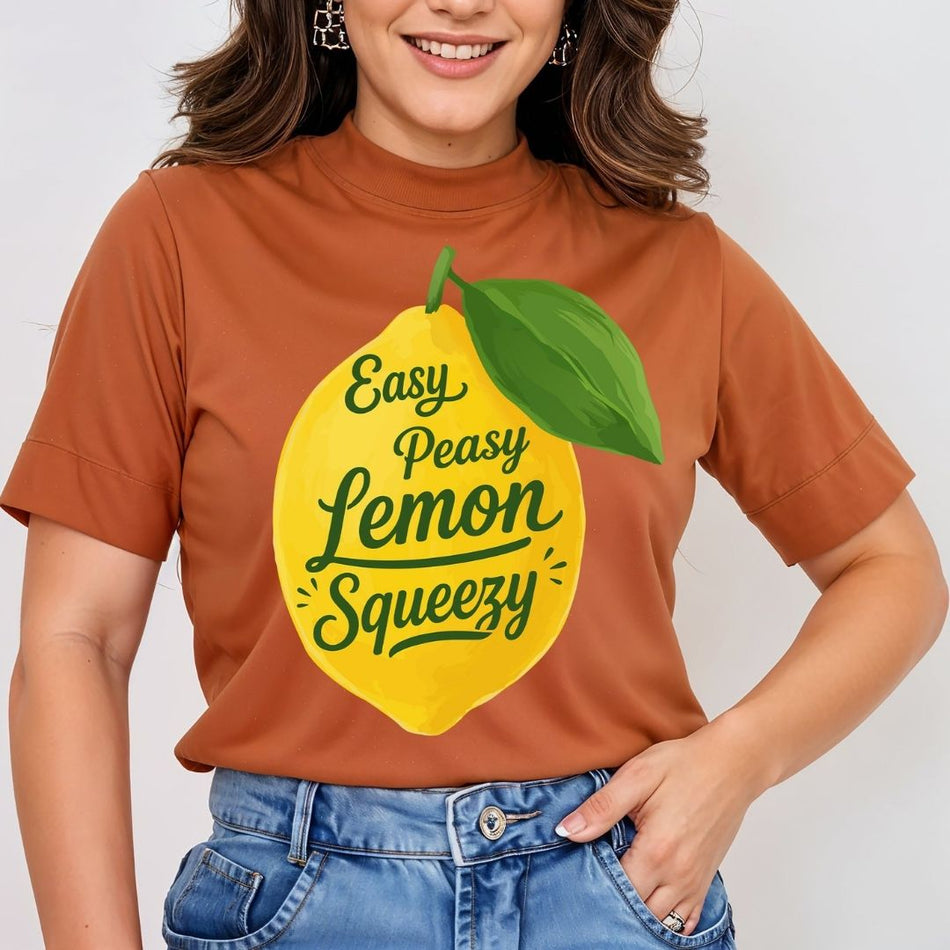 A smiling woman modeling a terracotta brown mock-neck t-shirt featuring a large yellow lemon design printed on the front with the text "Easy Peasy Lemon Squeezy".