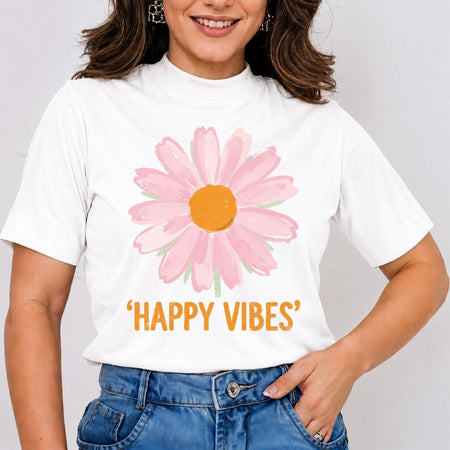 A woman wearing a white short-sleeve t-shirt with a pink daisy graphic and the text 'HAPPY VIBES' in orange, paired with blue jeans.