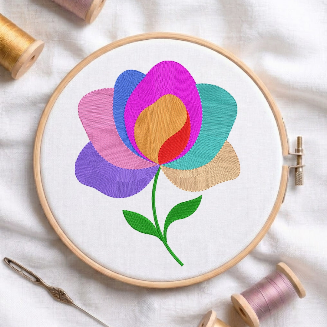 Embroidery hoop with a colorful flower design on a white fabric background.