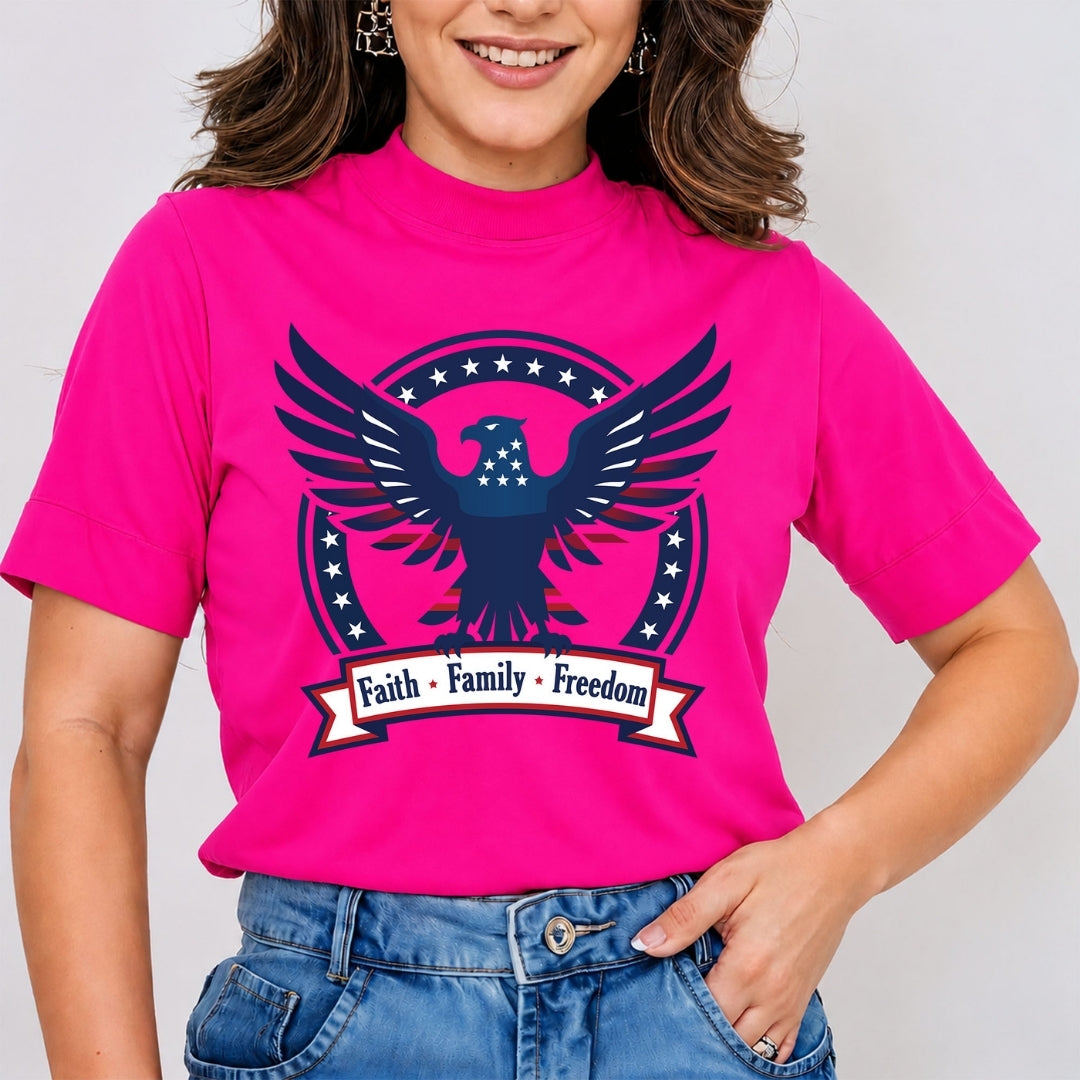 A close-up of a person wearing a hot pink t-shirt featuring a patriotic eagle graphic and the text "Faith • Family • Freedom".