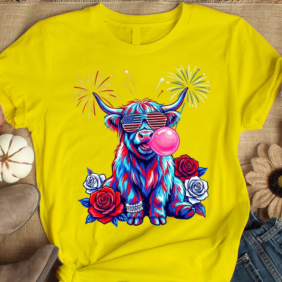 Yellow t-shirt with a colorful cow design blowing bubbles and wearing sunglasses on a textured surface.