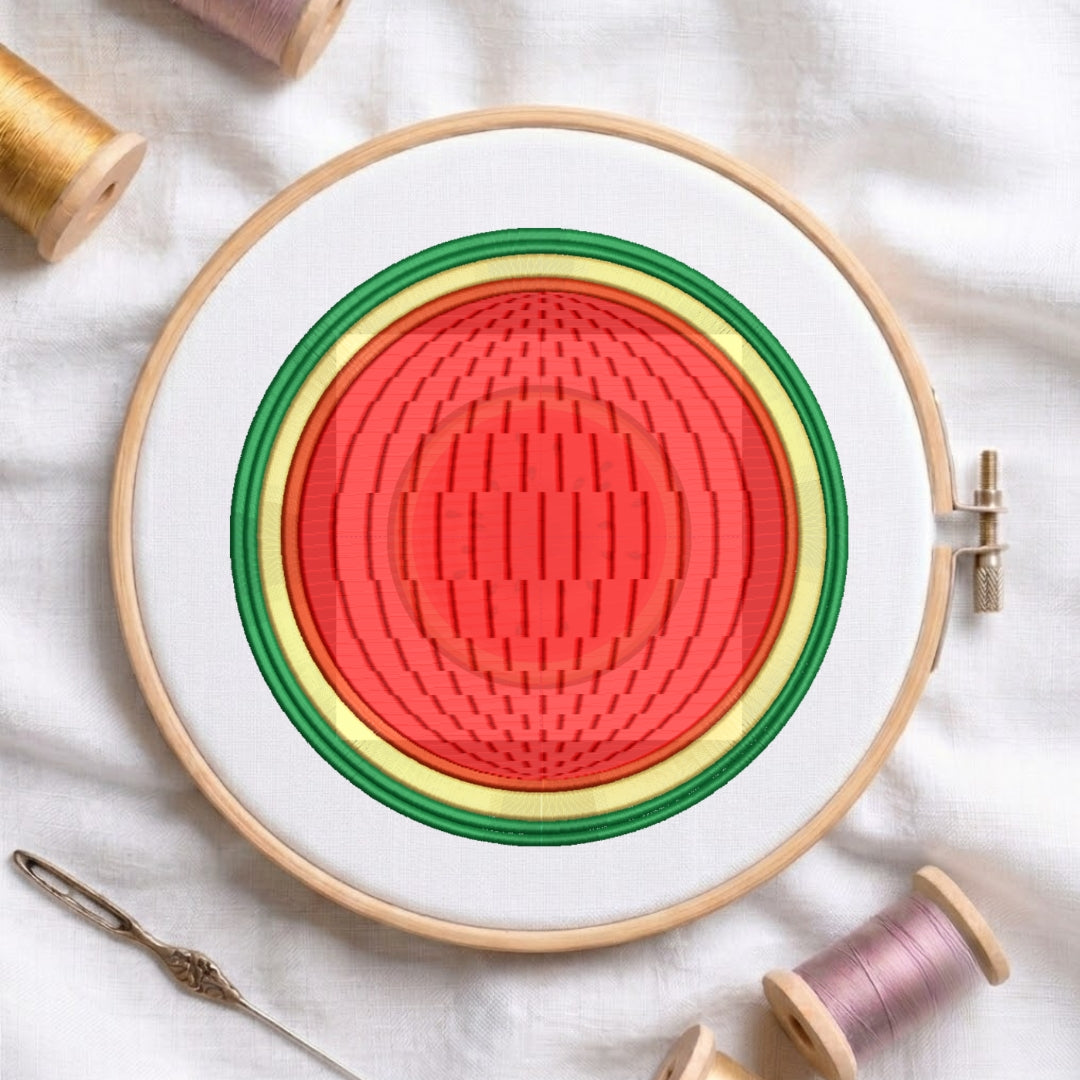 A circular embroidery hoop holding white fabric with concentric stitched rings in red, yellow, green, and white. Spools of thread and a needle are arranged around it on a white fabric background.