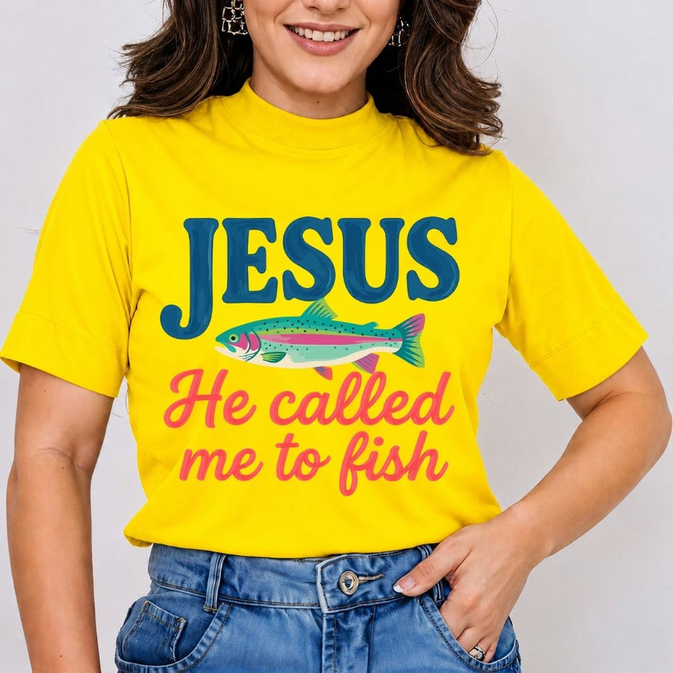 A smiling woman wearing a bright yellow mock-neck t-shirt featuring a large Christian "Jesus He Called Me to Fish" text graphic with a rainbow trout printed on the front.