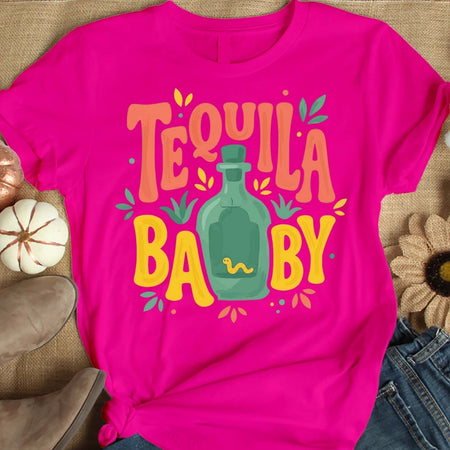 Pink t-shirt with 'Tequila Baby' graphic on a textured surface