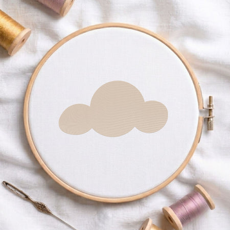 Minimalist cute cloud machine embroidery design shown in a wooden embroidery hoop on white fabric with thread spools and a needle   