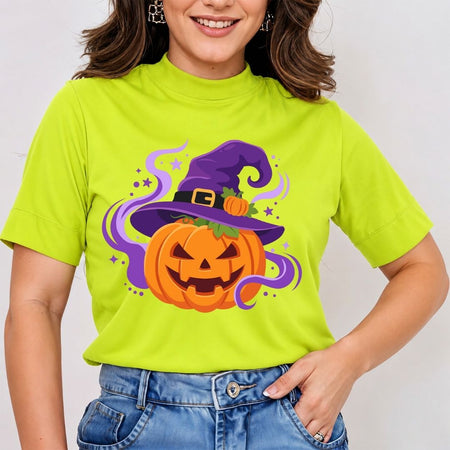 A woman wearing a bright lime green mock-neck t-shirt with a cartoon graphic of a jack-o'-lantern pumpkin wearing a purple witch hat, paired with blue jeans.