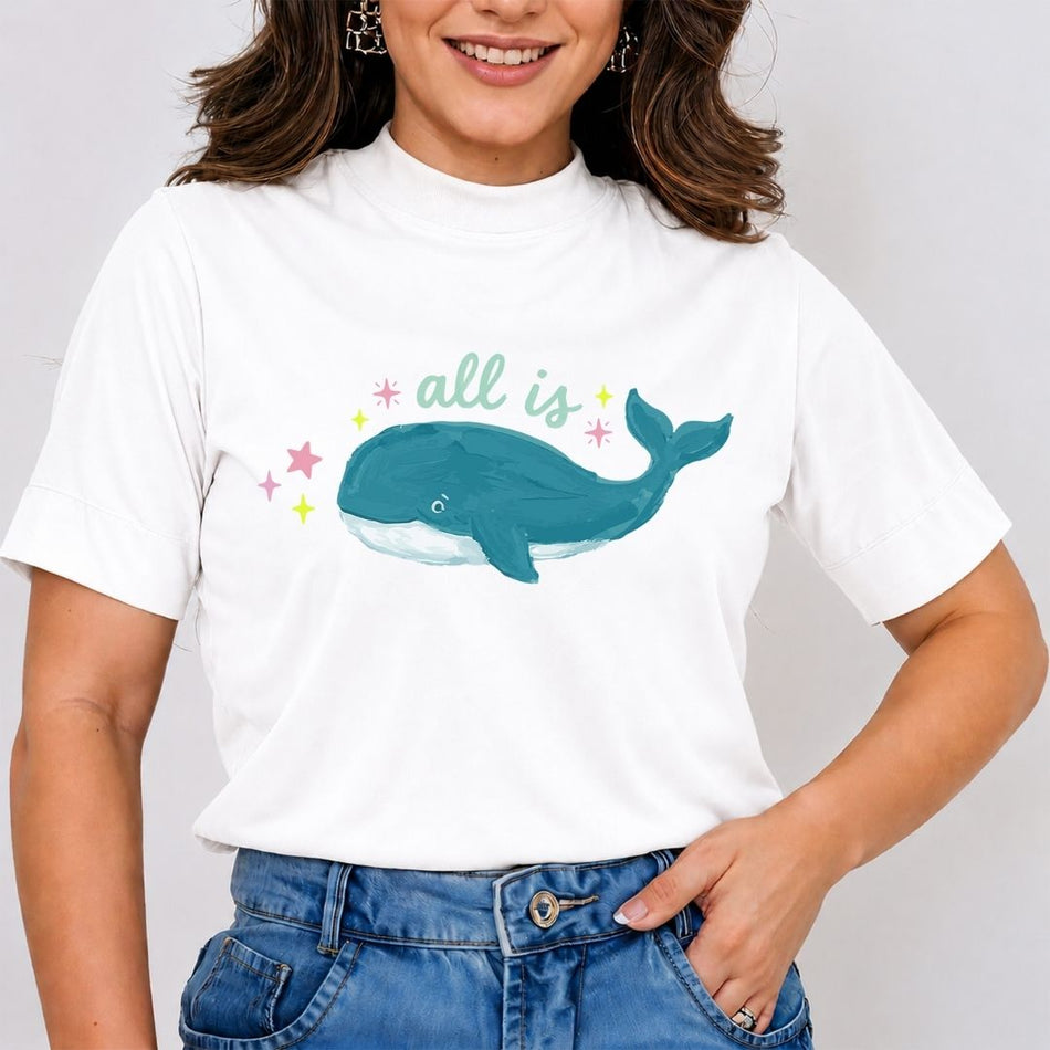 Person wearing a white t-shirt with a whale graphic and text on a plain background