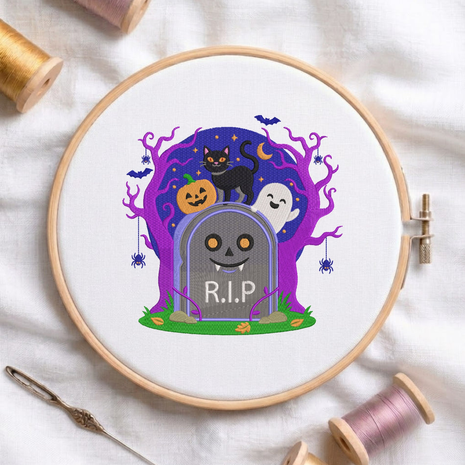 A circular embroidery hoop holding white fabric with a colorful Halloween-themed stitched design: a gray tombstone reading R.I.