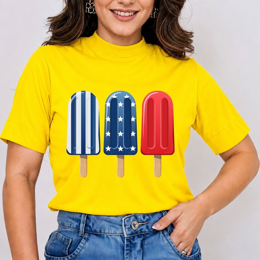 Person wearing a yellow t-shirt with colorful popsicle graphics on a plain background