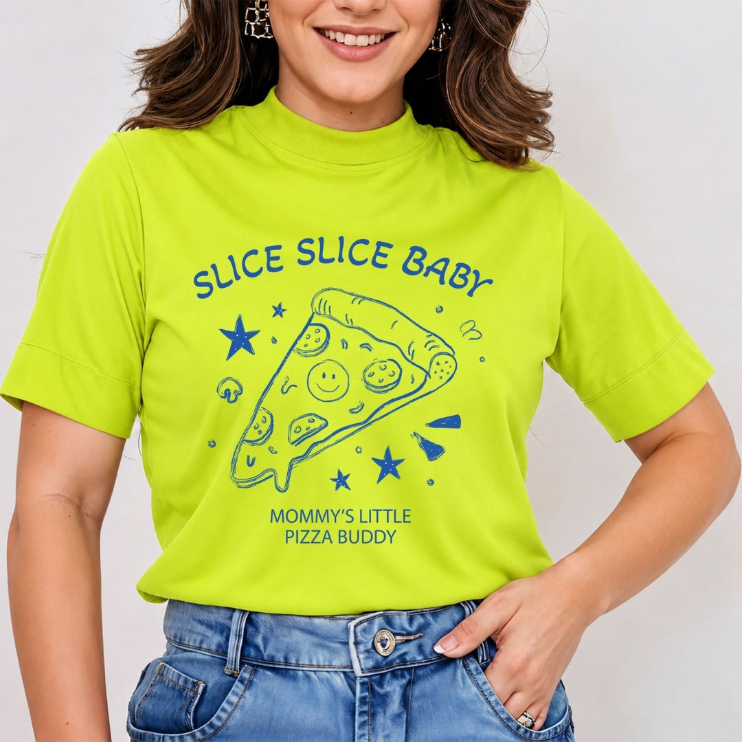 Woman wearing a bright lime green mock neck t-shirt featuring a blue retro line art graphic of a pizza slice with the text "Slice Slice Baby Mommy's Little Pizza Buddy", tucked into jeans.