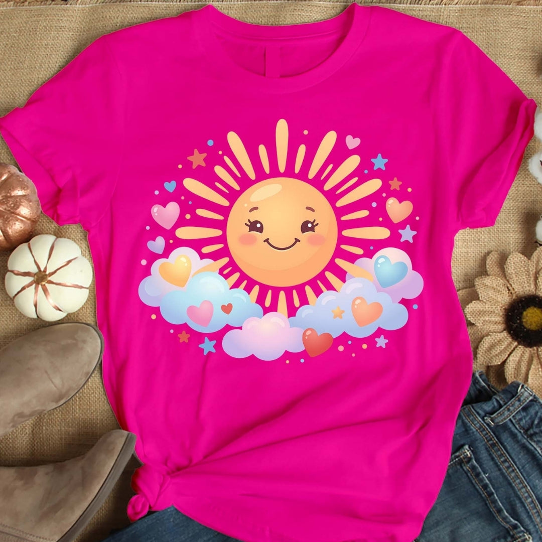 Pink t-shirt with a sun and cloud design on a textured surface