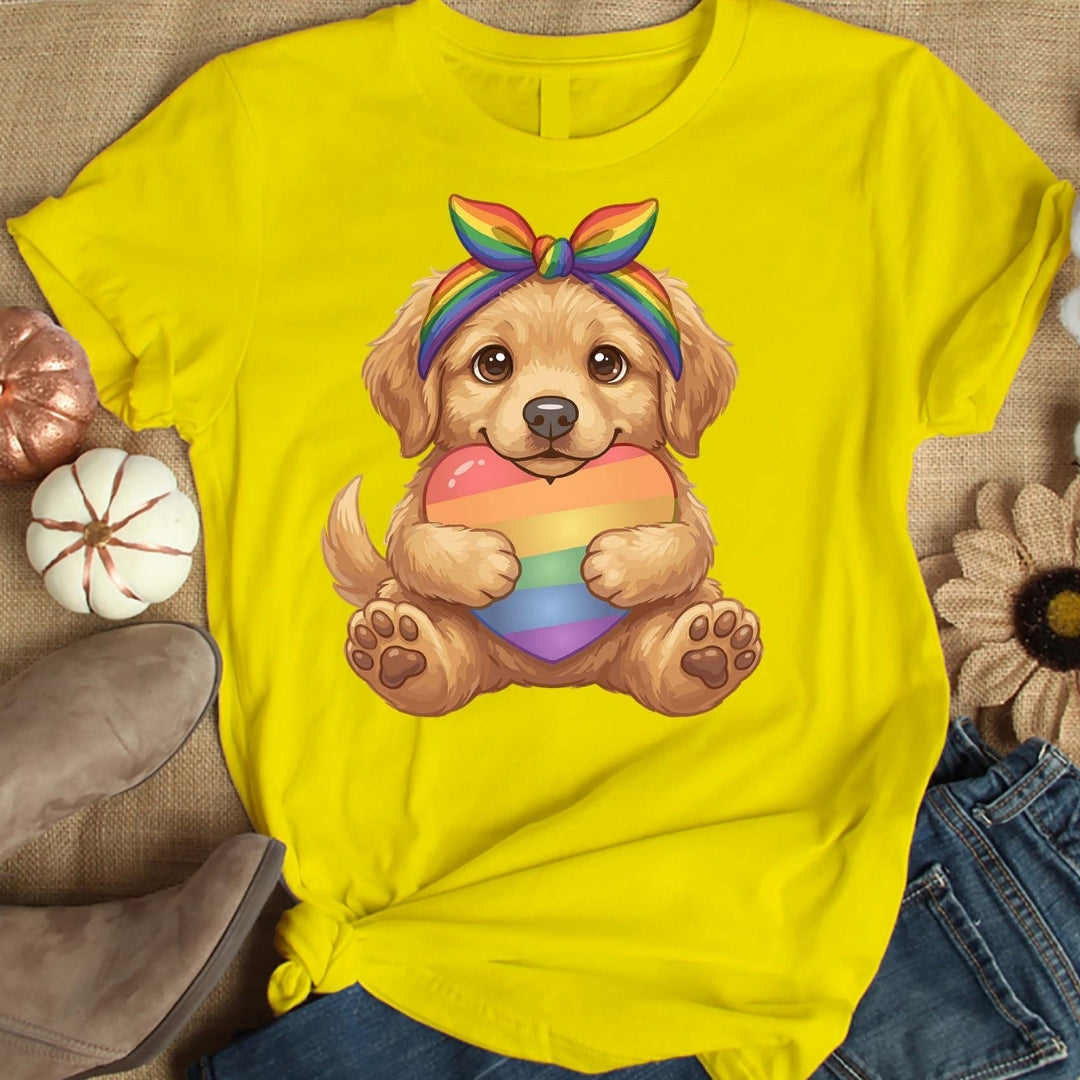 Yellow t-shirt with a dog holding a rainbow heart design on a textured surface.