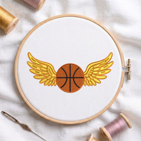 Embroidery hoop with a basketball design featuring wings on a white fabric background.