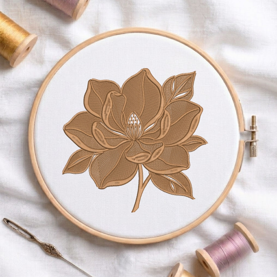 The floral embroidery design secured in a wooden embroidery hoop, displayed with embroidery thread spools and a needle on a white fabric background.