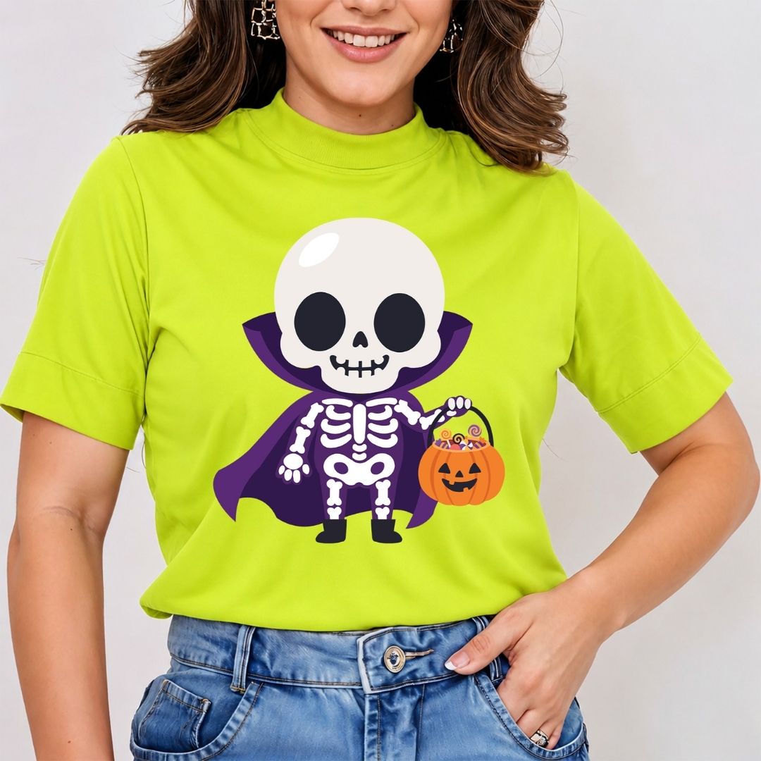 A woman wearing a bright lime green mock-neck t-shirt with a cartoon graphic of a skeleton vampire holding a pumpkin candy basket, paired with blue jeans.