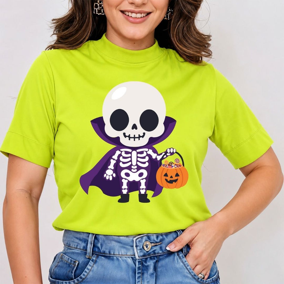 A woman wearing a bright lime green mock-neck t-shirt with a cartoon graphic of a skeleton vampire holding a pumpkin candy basket, paired with blue jeans.