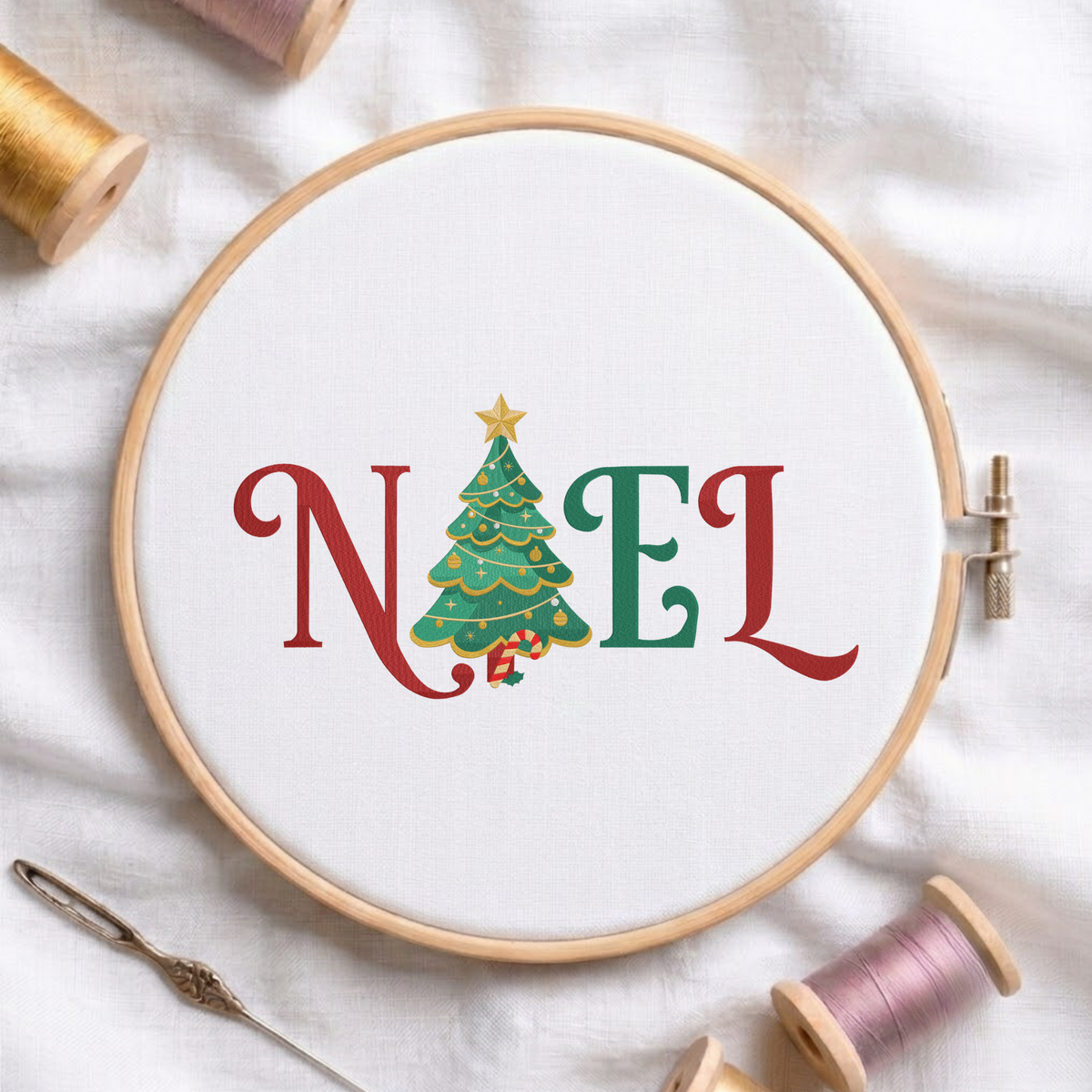 "NOEL" festive Christmas lettering featuring a decorated Christmas tree with a star topper replacing the letter O machine embroidery design shown in a wooden embroidery hoop on white fabric with thread spools and a needle