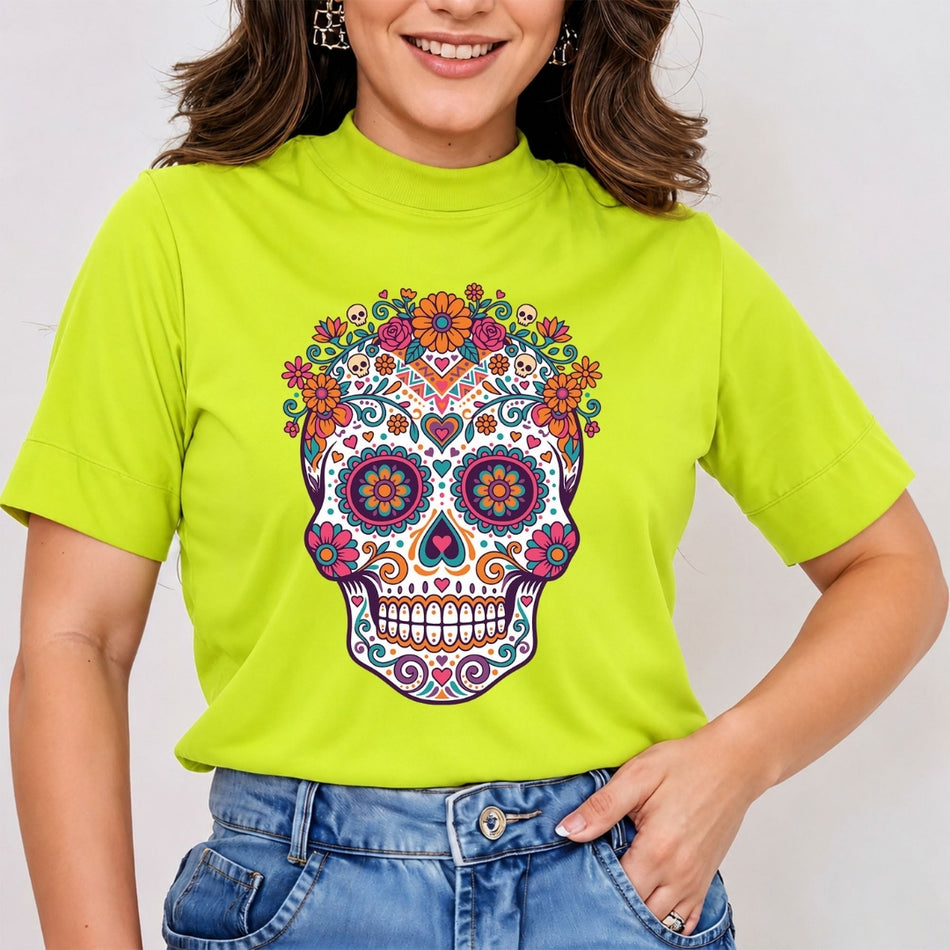 A woman wearing a bright lime green mock-neck t-shirt with a colorful sugar skull graphic on the front, paired with blue jeans.