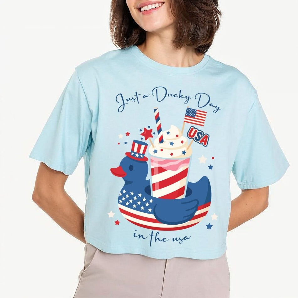 A smiling woman wearing a bright lime green mock-neck t-shirt featuring a large patriotic slushie cup design printed on the front.