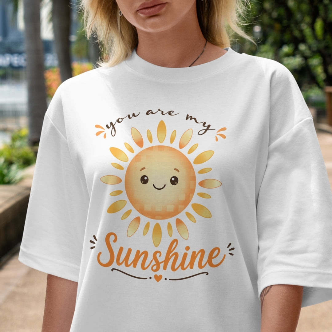 Person wearing a white t-shirt with a sun graphic and 'you are my sunshine' text.