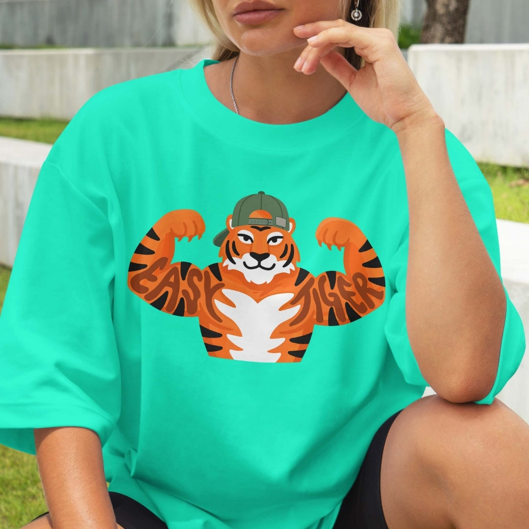 Person wearing a teal t-shirt with a tiger graphic design outdoors.