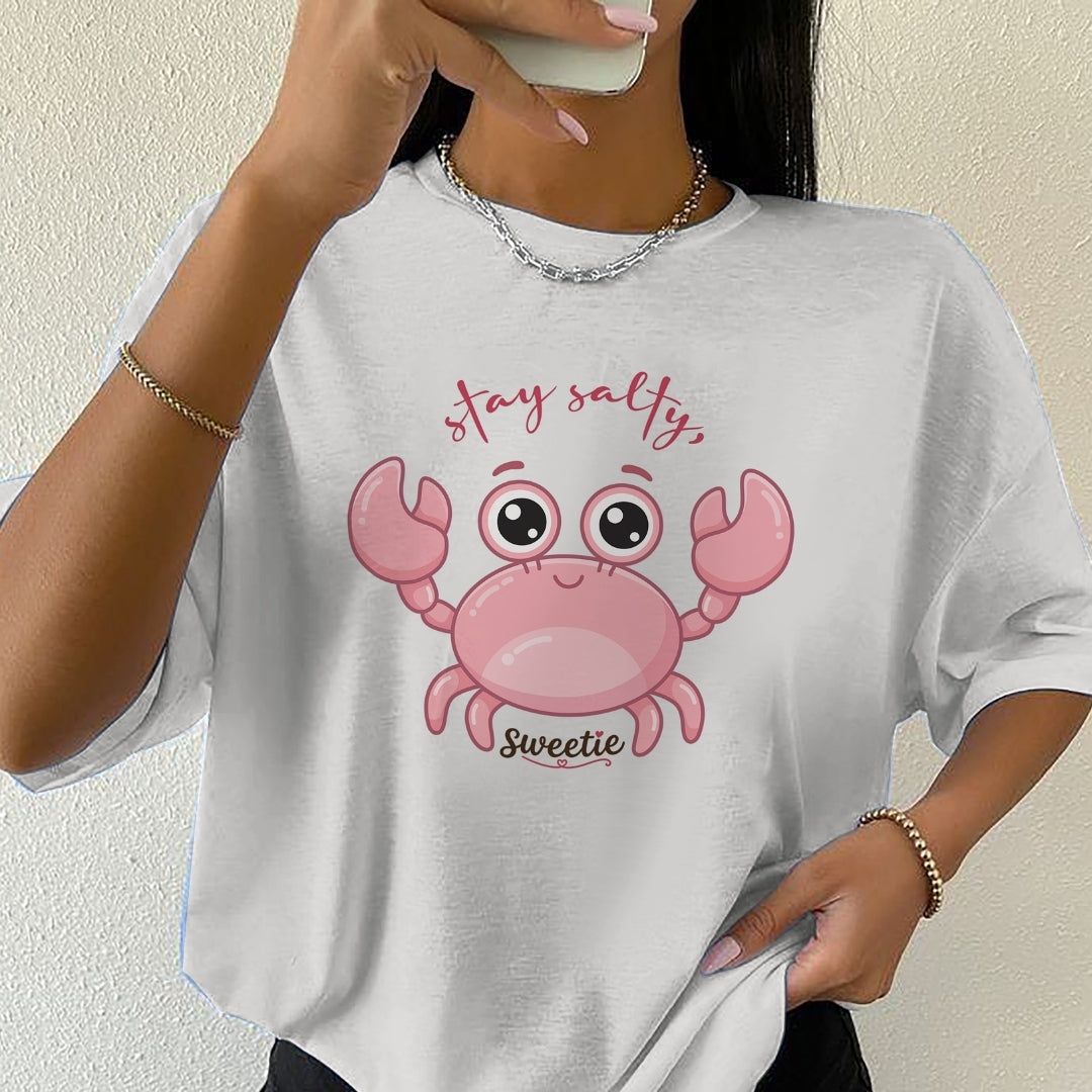 Person wearing a white t-shirt with a pink crab graphic and text.