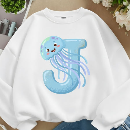 A white oversized sweatshirt mockup featuring a light blue letter J graphic adorned with a smiling pastel jellyfish.