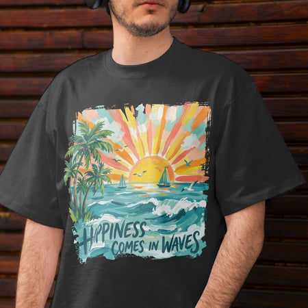 A man wearing a black graphic t-shirt with a colorful tropical sunset and ocean print that reads 'HAPPINESS COMES IN WAVES', set against a dark wooden plank background.