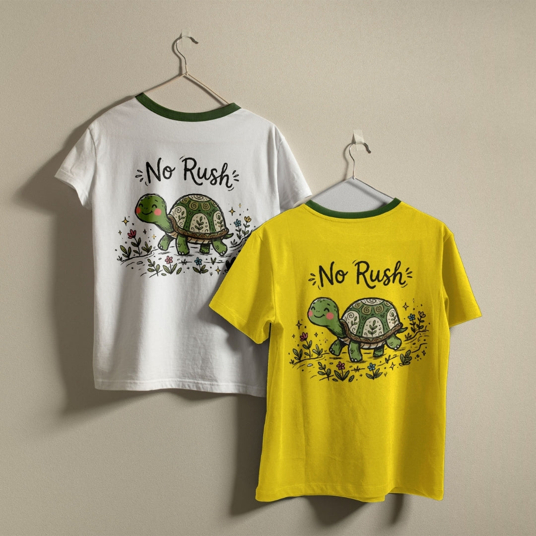 White and yellow t-shirts hanging on a wall, both displaying the cute turtle "No Rush" graphic printed on the back.