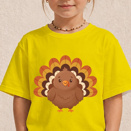 A child wearing a bright yellow short-sleeve t-shirt with a cartoon turkey graphic on the front, set against a light textured wall.