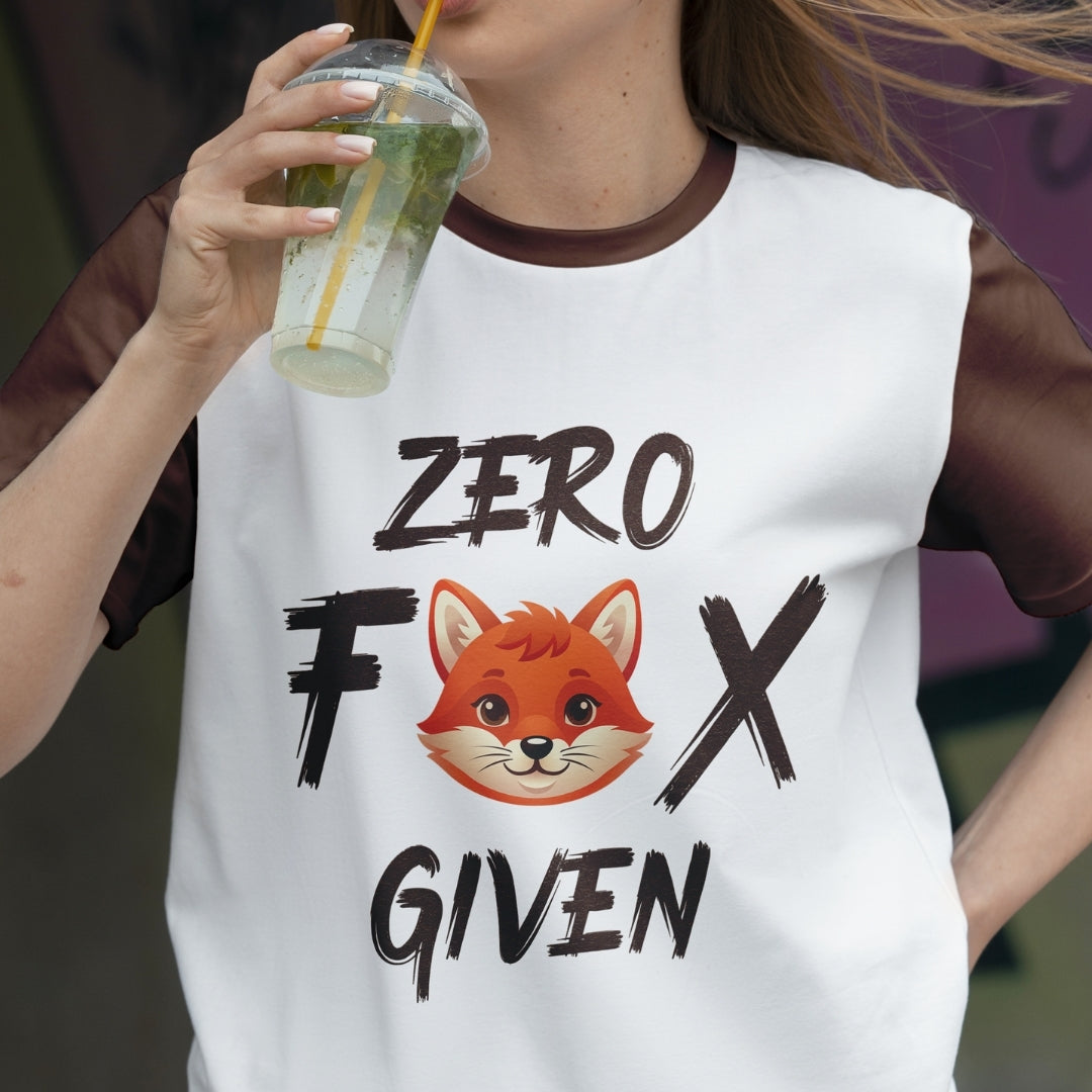 Person wearing a white t-shirt with a fox graphic and text, holding a drink.