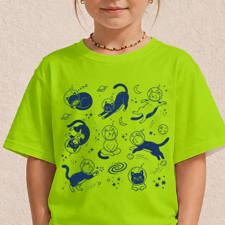 A child wearing a bright neon yellow-green t-shirt with a dark blue cartoon cat space-themed graphic print, set against a textured beige wall.