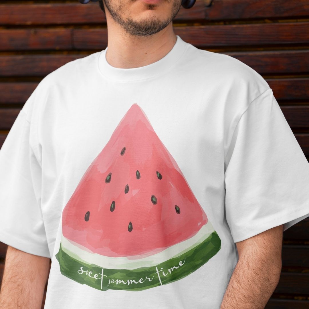 Close up of a man wearing a white oversized t-shirt showing a hand-drawn watermelon sublimation print with green rind detail and summer typography.