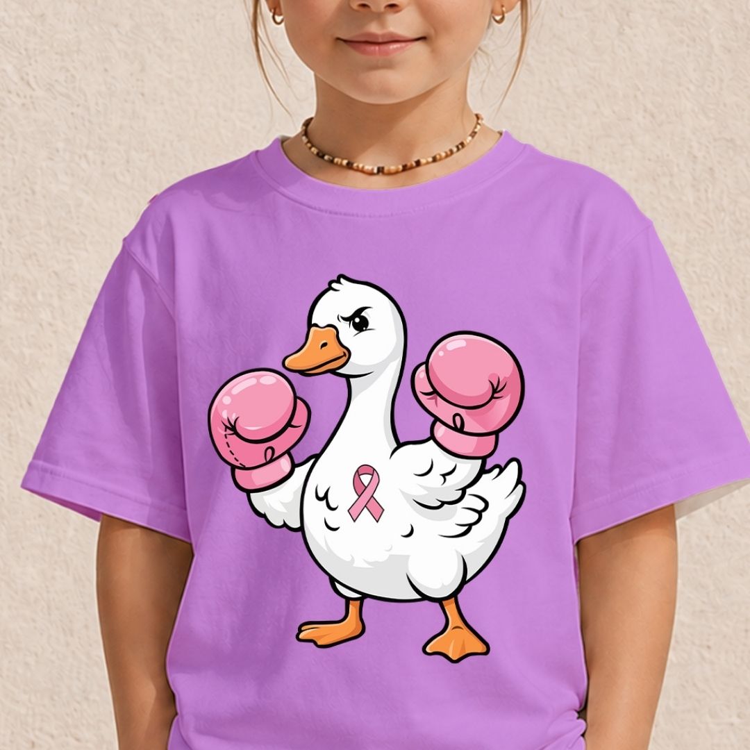 A child wearing a purple short-sleeve t-shirt with a cartoon graphic of a white duck wearing pink boxing gloves and a pink ribbon on its chest, set against a textured beige wall.