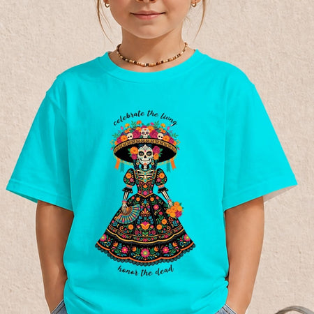 A child wearing a bright turquoise short-sleeve T-shirt with a colorful Day of the Dead graphic featuring a skeleton in a floral sombrero and the words 'celebrate the lying' and 'honor the dead'.