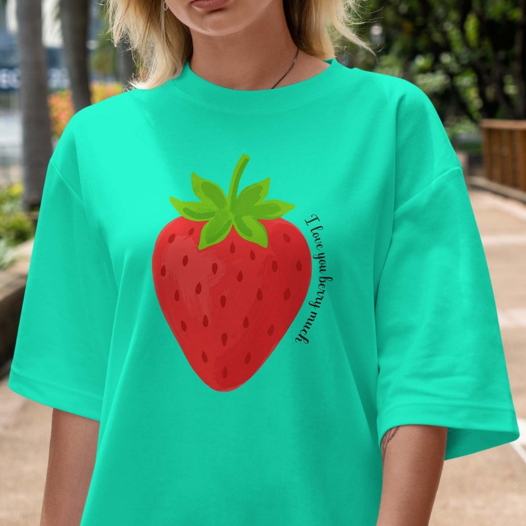 Person wearing a teal t-shirt with a strawberry graphic and text.