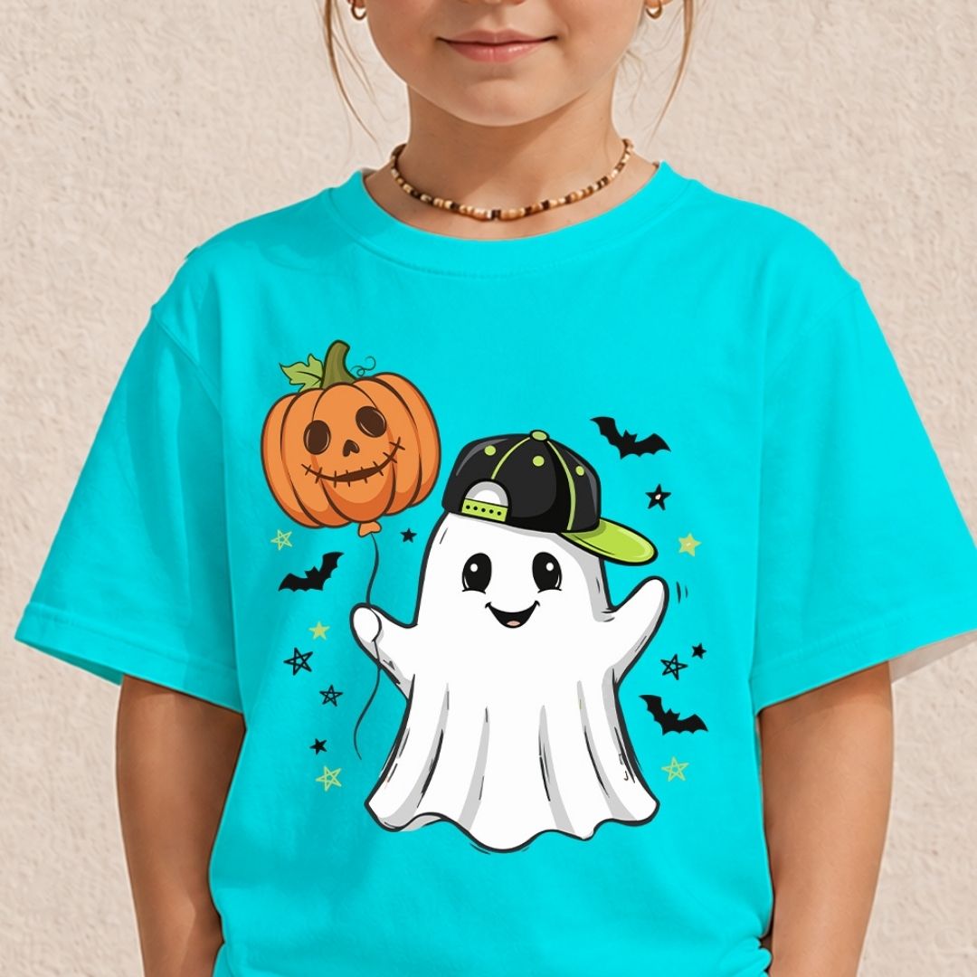A child wearing a bright turquoise short-sleeve T-shirt with a Halloween graphic of a smiling white ghost wearing a black and green cap, next to a jack-o'-lantern holding a balloon, with small bats and stars.