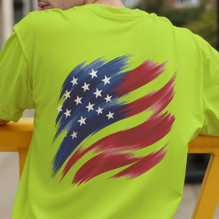 A person seen from the back wearing a neon lime-green t-shirt featuring a stylized brushstroke American flag graphic.