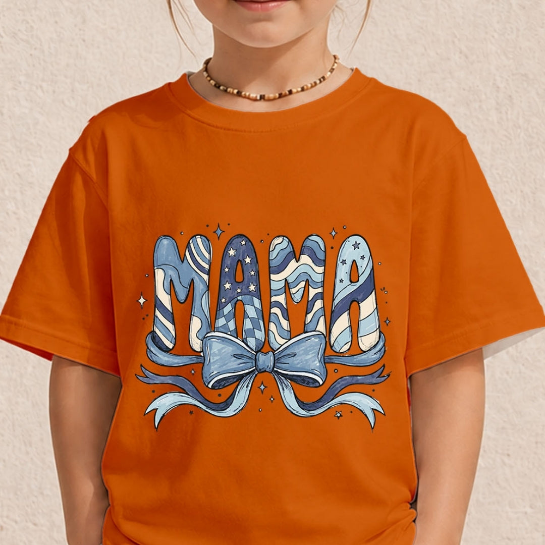 Close-up of a child wearing a bright orange t-shirt printed with a decorative blue and cream "MAMA" letter design topped with a large ribbon bow.