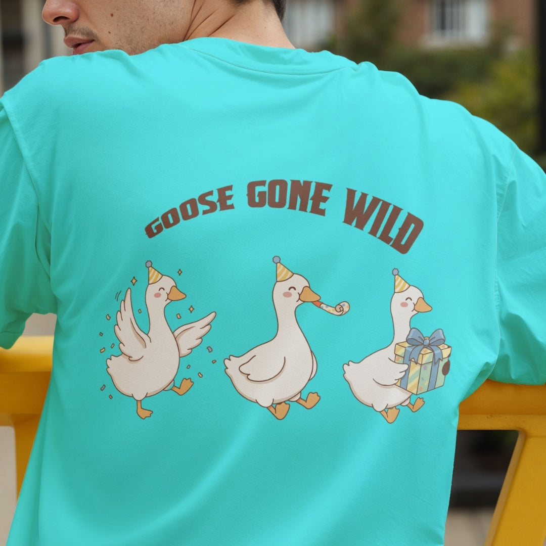 Back view of a person wearing a bright turquoise t-shirt showcasing a funny graphic of three partying geese wearing hats with the text "GOOSE GONE WILD".