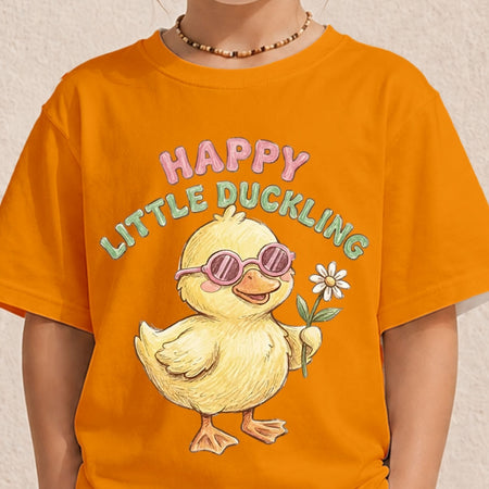 A person wearing a bright orange graphic T-shirt with a cartoon duckling wearing pink sunglasses and holding a white flower, with the text 'HAPPY LITTLE DUCKLING' above it.