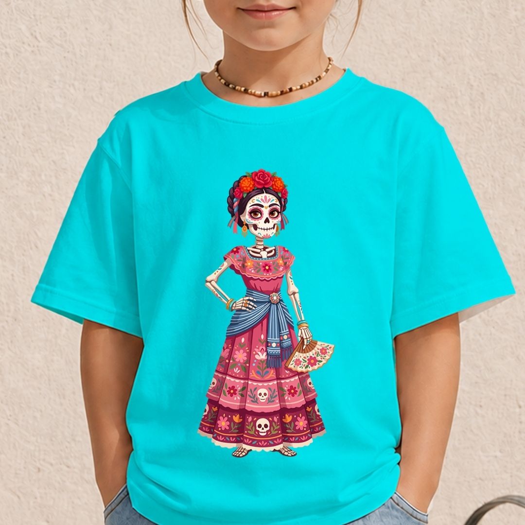 A child wearing a bright turquoise short-sleeve T-shirt with a colorful Day of the Dead sugar skull girl graphic on the front, photographed against a light beige textured wall.