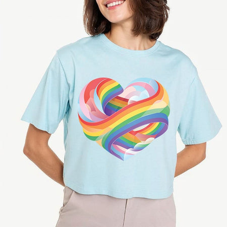 Person wearing a light blue t-shirt with a colorful heart design on a plain background