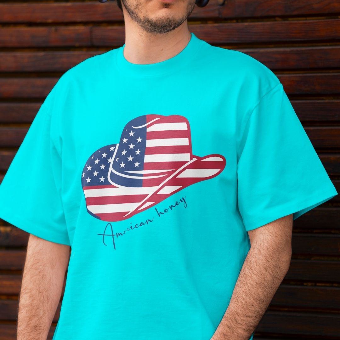 Close up of a man wearing a bright turquoise blue t-shirt displaying a large American flag cowboy hat sublimation print across the front.