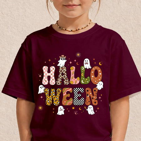 A child wearing a dark burgundy t-shirt with a colorful 'HALLOWEEN' graphic featuring patterned letters, ghosts, and stars, set against a textured beige wall.