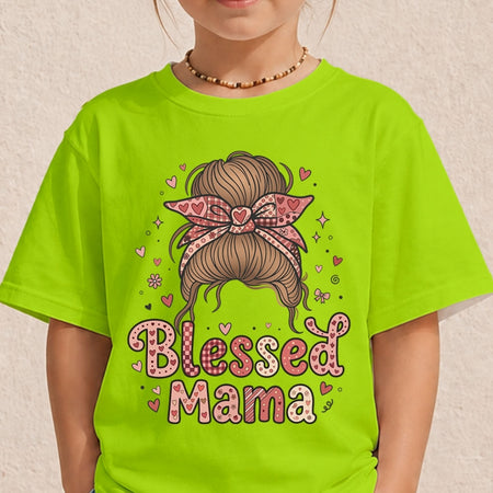 A child wearing a bright lime green t-shirt with a graphic of a messy brown bun with a pink heart-patterned bow and the words 'Blessed Mama' in pink and white patterned letters.