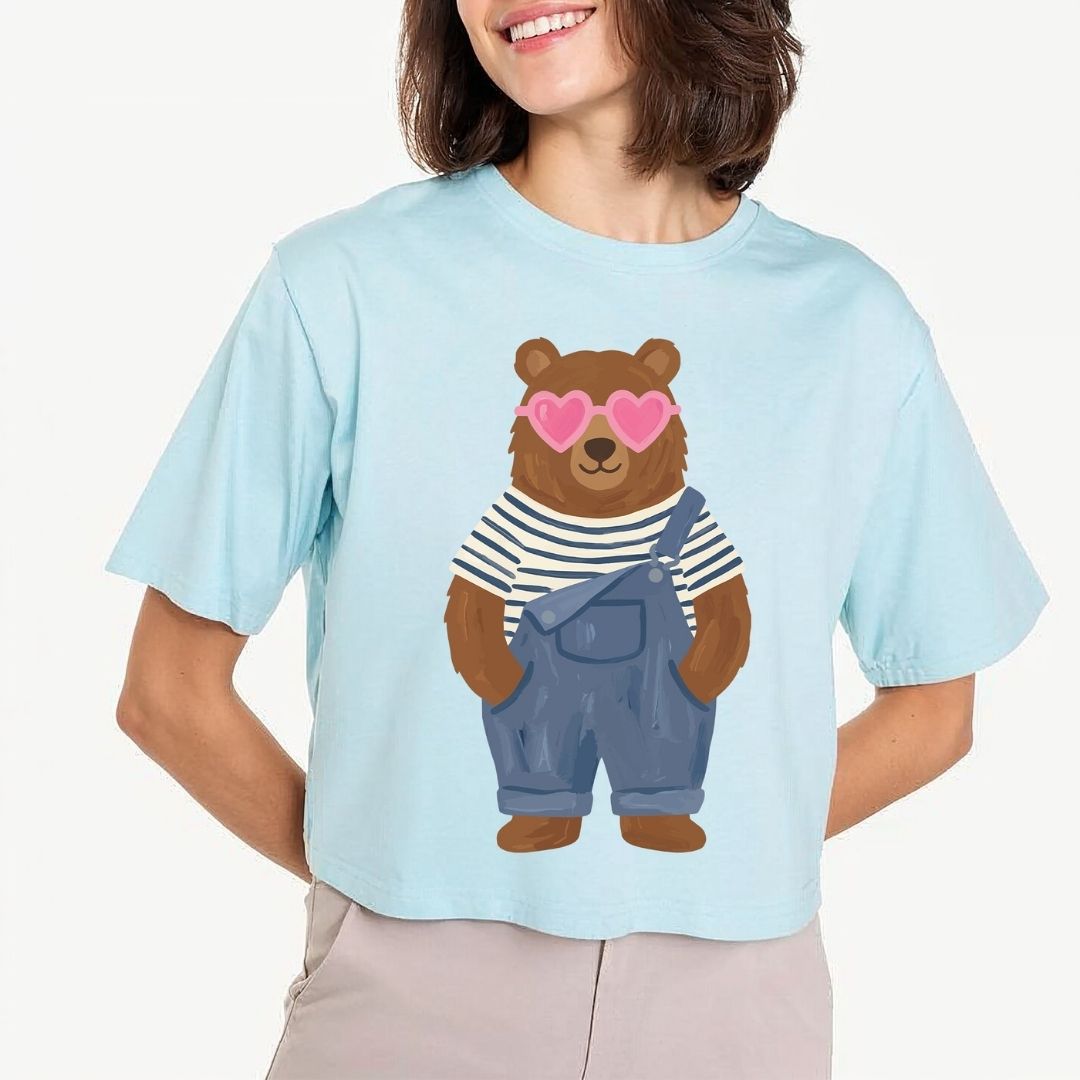 Person wearing a light blue t-shirt with a bear graphic design.